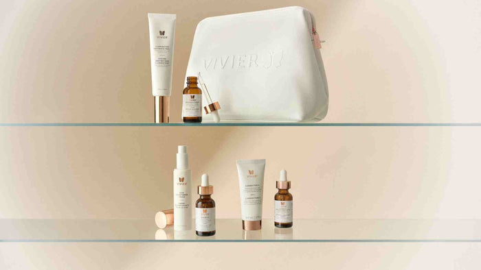 Vivier skincare products displayed alongside a white cosmetic bag, featuring serums, treatments, and moisturizers arranged on glass shelves.