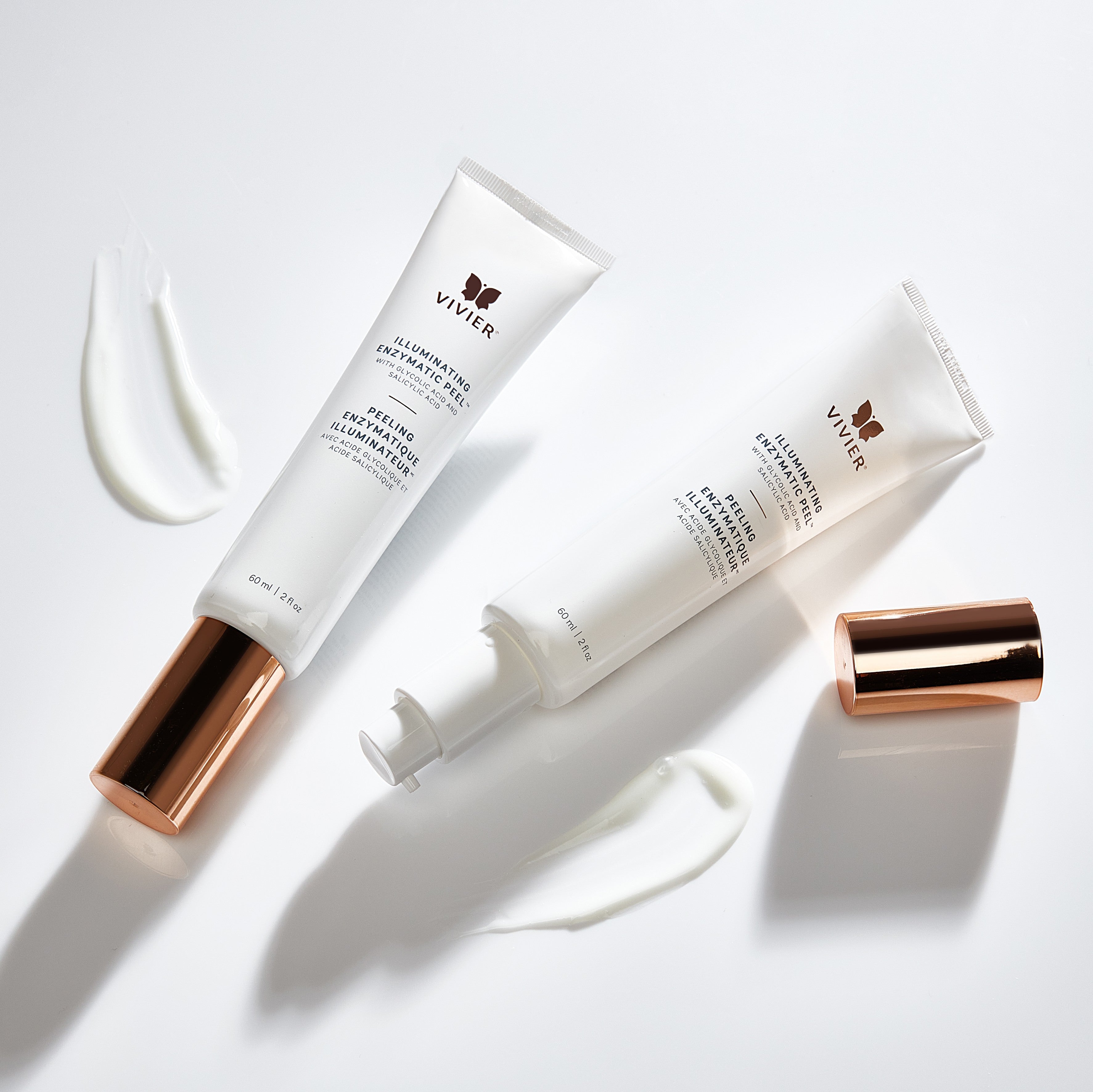Vivier Illuminating Enzymatic Peel tubes displayed on a white surface with product texture and rose gold cap