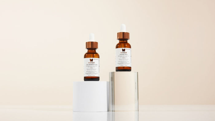 Vivier TX Jessner Plus and Vivier Peel professional treatments displayed in amber dropper bottles on minimalist pedestals.