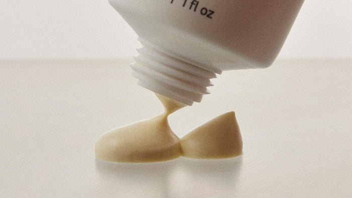 Close-up of a skincare cream being dispensed from a tube, highlighting its rich, creamy texture.